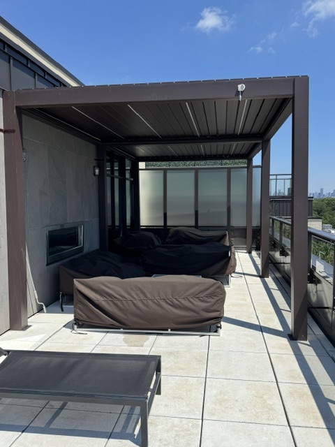Rooftop lounge under the pergola with outdoor fireplace and seating